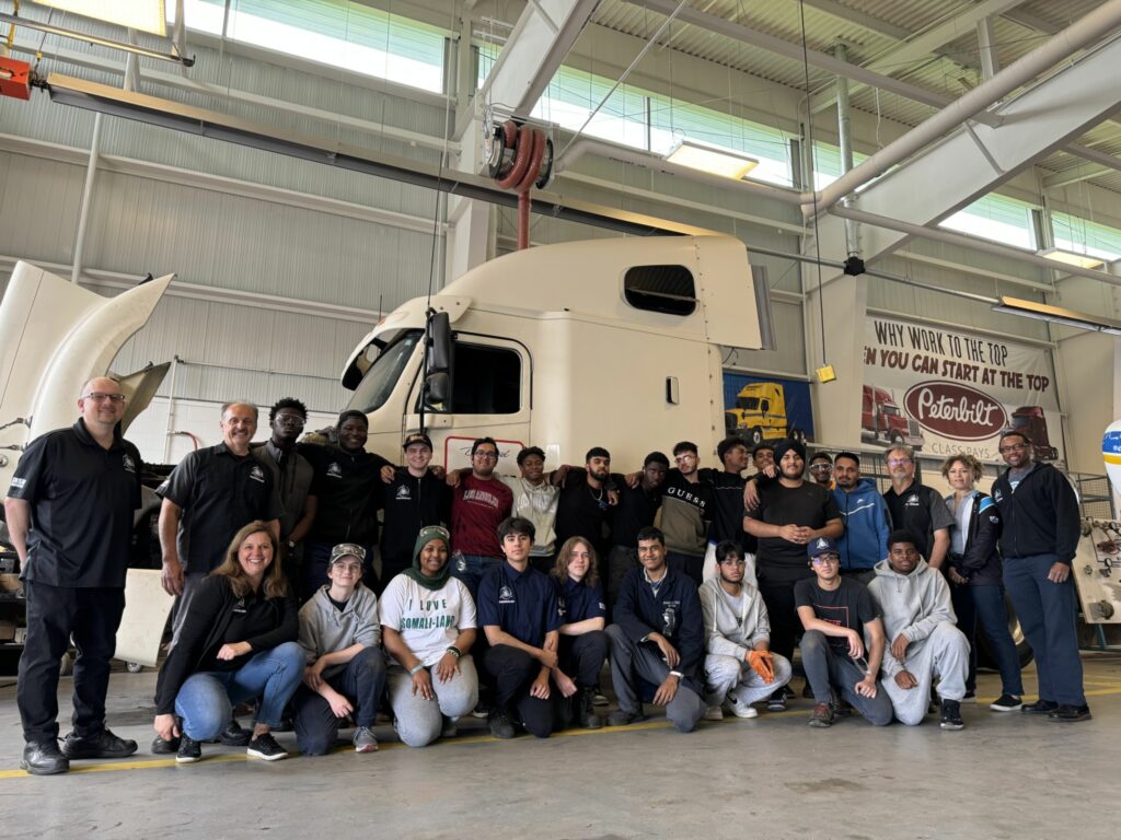Bramelea transportation program students with their teachers in the shop in front of a truck