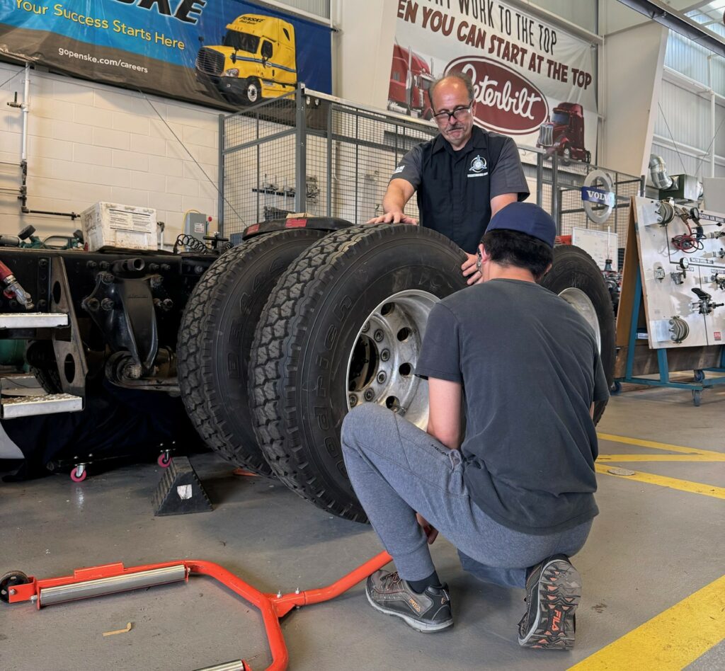 Teacher helping a student with wheels on the truck 